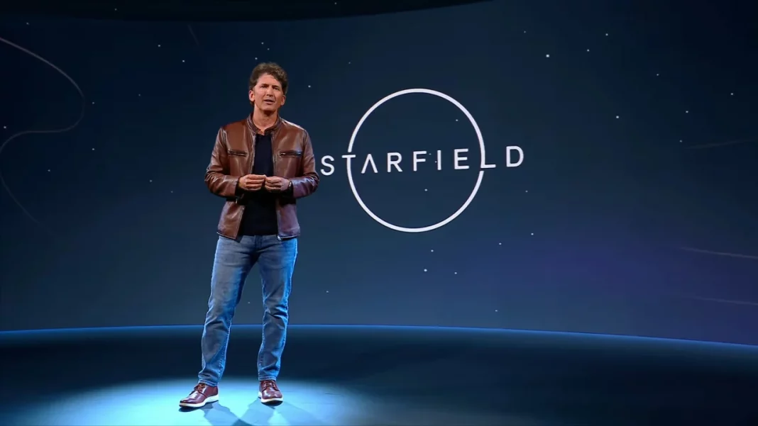 Todd Howard lors d'une conférence de presse, présentant Starfield, avec un visuel épique du jeu en arrière-plan.
