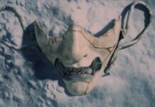 Ghost of Yotei aura son show en juillet Masque d’Atsu dans Ghost of Yōtei, accessoire emblématique du personnage sur fond enneigé