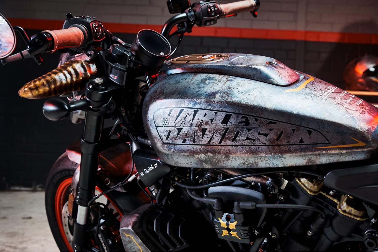 Logo Harley-Davidson gravé sur un réservoir aux teintes sombres et texturées