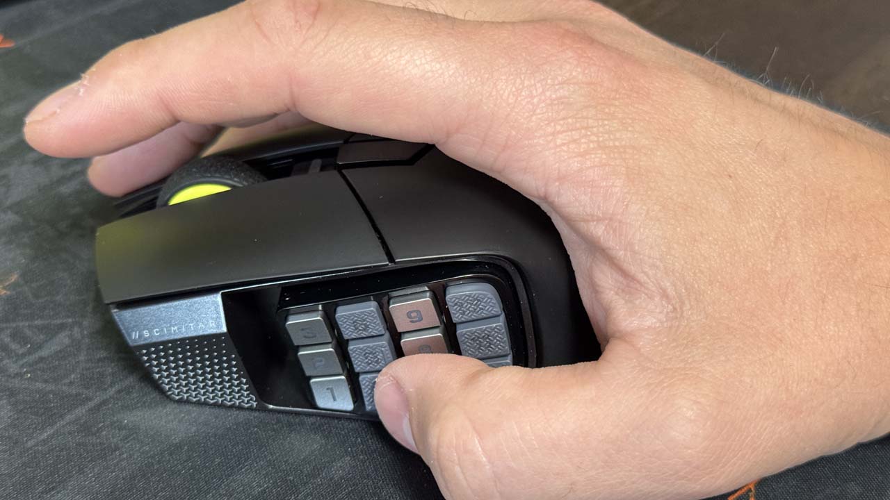 Main en prise sur la Corsair Scimitar Elite Wireless SE, zoom sur le pavé latéral de la souris