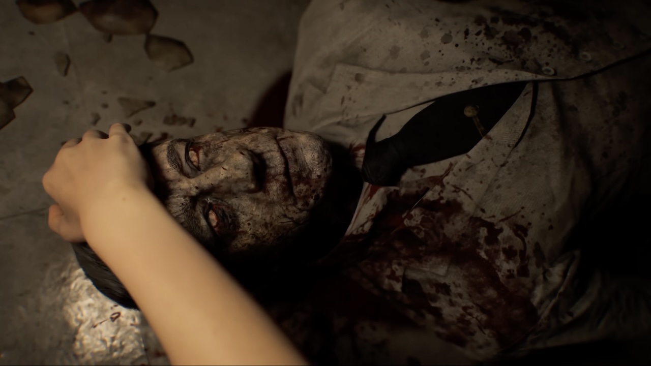 Main de Grace Ashcroft examinant un cadavre au regard vitreux dans une séquence horrifique de Resident Evil Requiem